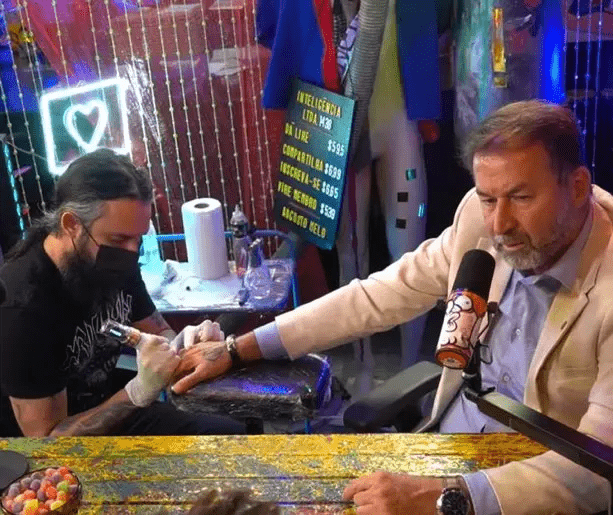 Augusto Melo fazendo tatuagem